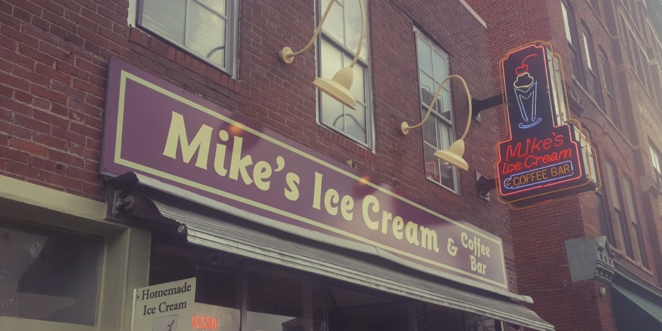 Storefront of mike's ice cream & coffee bar with signage and a neon sign illuminated above the entrance.